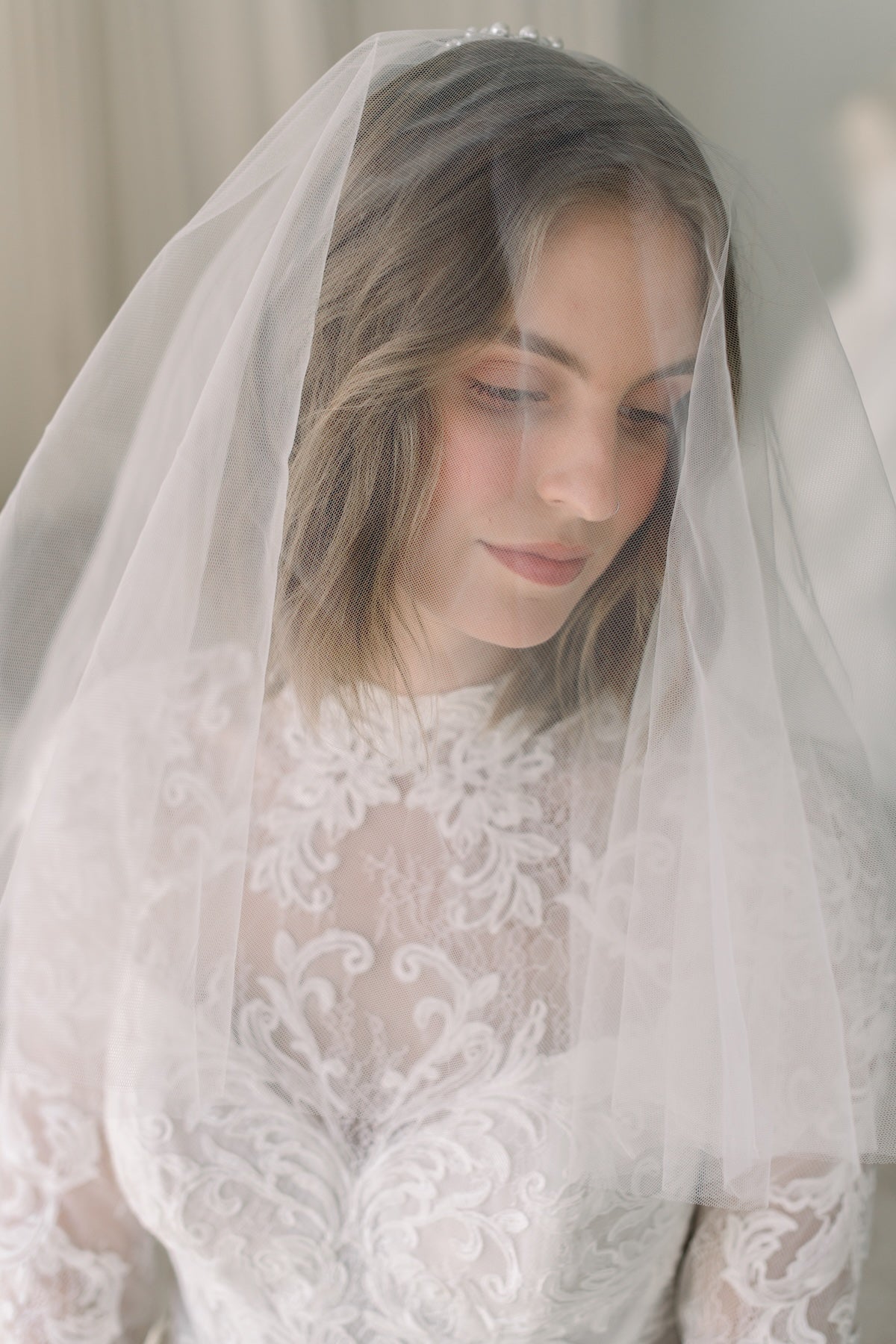 Woman wearing a white lace wedding dress with a veil