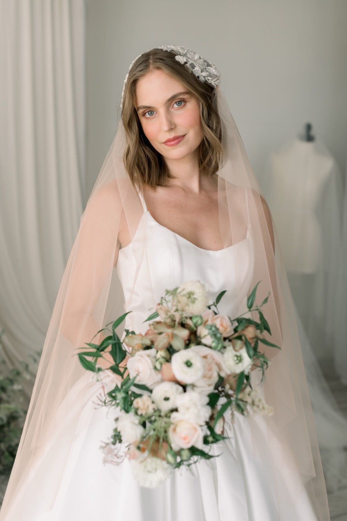 Bride holding a bouquet with a neutral background