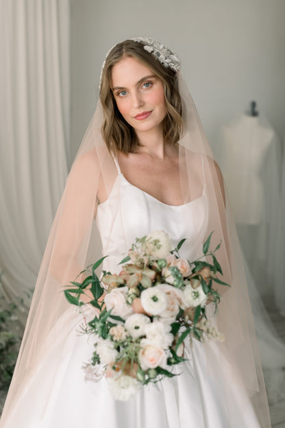Bride holding a bouquet with a neutral background