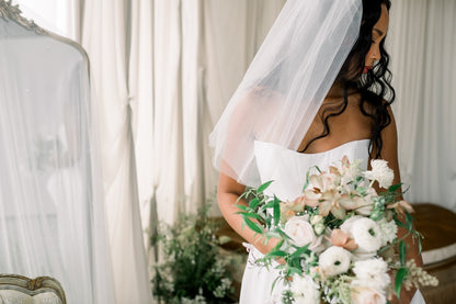 Bride holding a bouquet of flowers in a softly lit room.