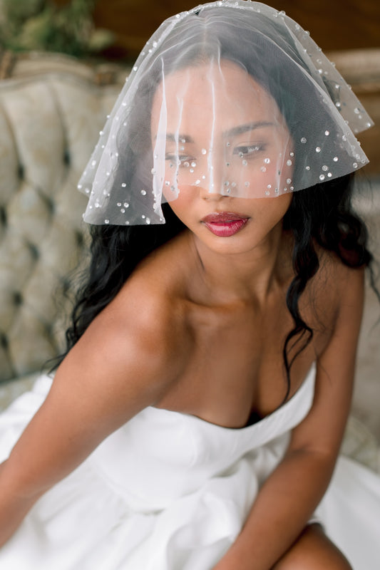 Woman wearing a white wedding dress with a clear veil