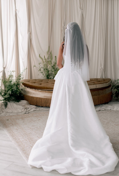 Person wearing a white wedding dress with a veil in a decorated indoor setting