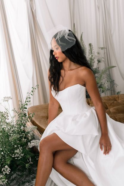Woman in a white dress sitting on a couch with floral decorations
