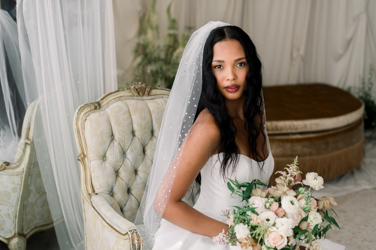 Woman in a wedding dress holding a bouquet in a decorated room