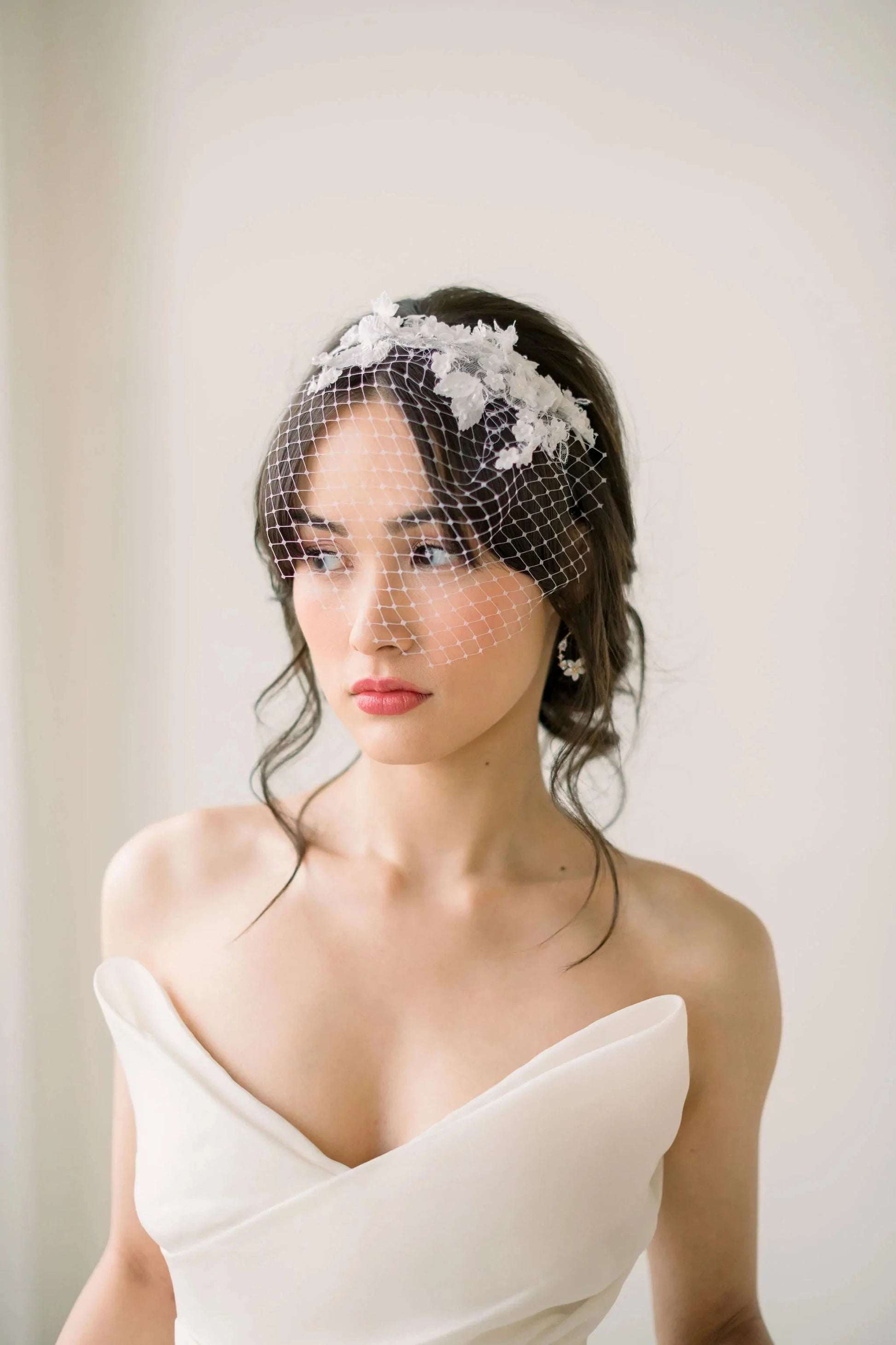 https://tessakim.com/cdn/shop/products/Mini-lace-birdcage-veil-on-headband-Tessa-Kim-894.webp?v=1675447439&width=1946